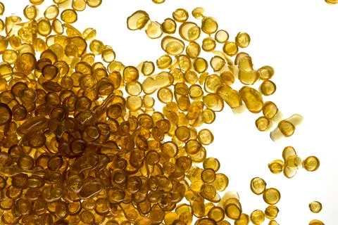 Amber-colored bone glue beads on a white background Foto stock