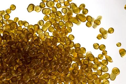 Amber-colored bone glue beads on a white background Foto stock