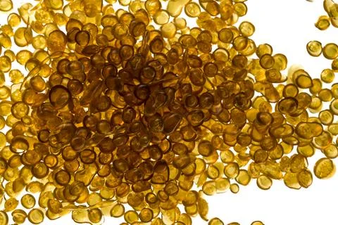 Amber-colored bone glue beads on a white background Stock Photos