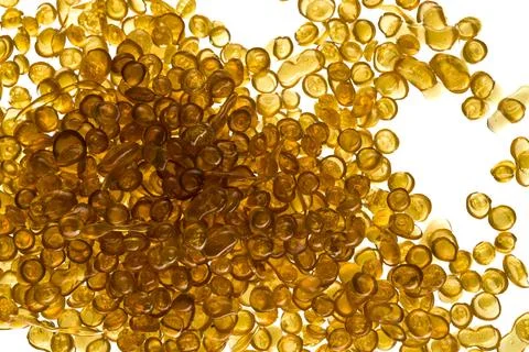 Amber-colored bone glue beads on a white background Stock Photos