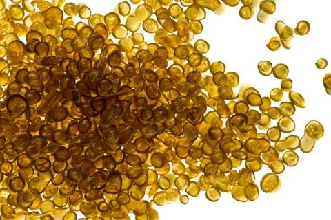 Amber-colored bone glue beads on a white background Stock Photos