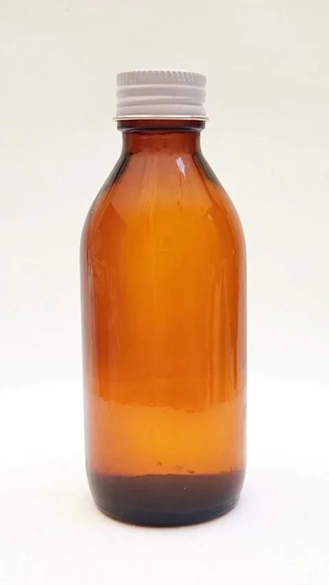 Amber glass bottle with cap rotating on white background, brown glass bottle Video stock 331978559