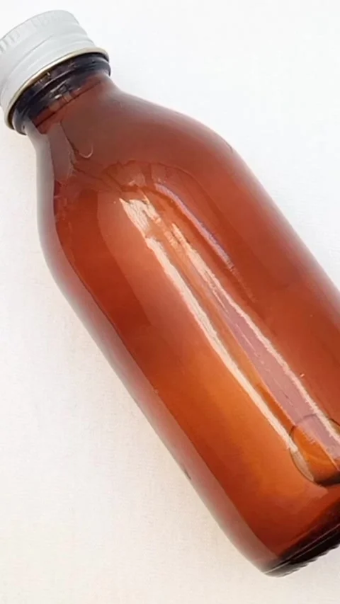 Amber glass bottle with cap rotating on white background, brown glass bottle 库存影片 331978700