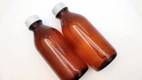 Amber glass bottles with cap rotating on white background, brown glass bottles  Stock-Footage 331978699