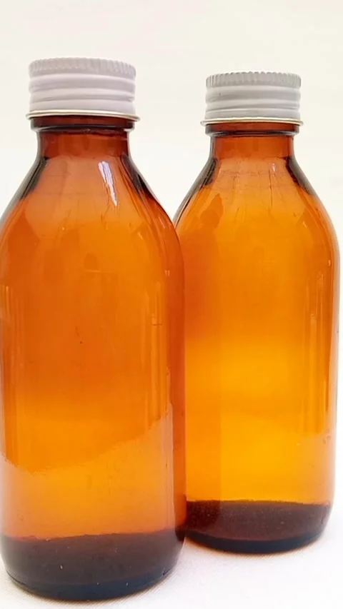Amber glass bottles with cap rotating on white background, brown glass bottles  Stock Footage 331978702