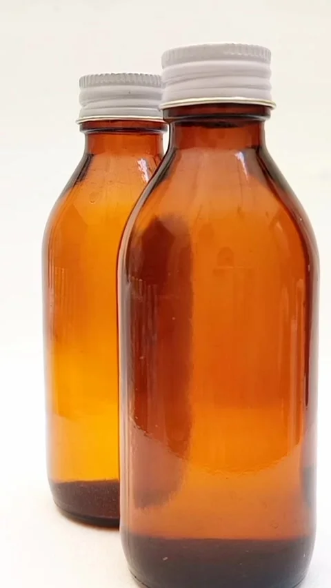 Amber glass bottles with cap rotating on white background, brown glass bottles  Video stock 331978703