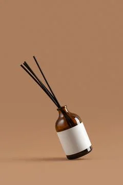 Amber glass reed diffuser with blank label on beige background. Minimalist ar Stock Photos