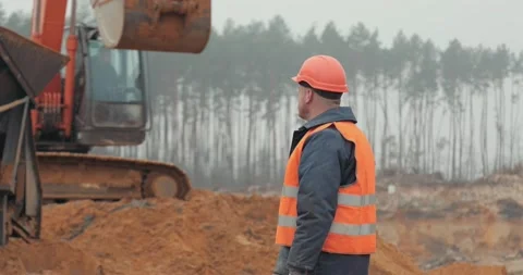 Amber mining by an excavator. A worker stands near an excavator Stock Footage 222958258