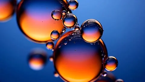 Amber oil bubbles float through clear blue water Video stock 317217377