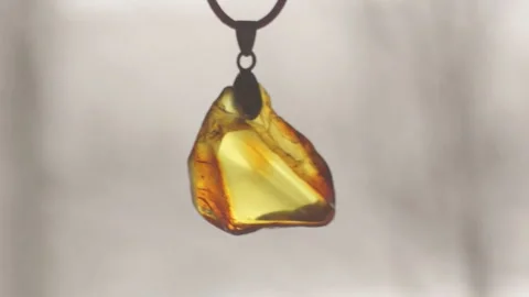 Amber pendant against a background of falling snow. Ukraine. Jewelry, yard. Stock-Footage 263734319