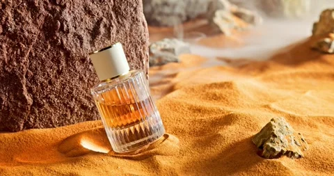 Amber perfumes in translucent glass bottle on sand. 動画素材 333538264