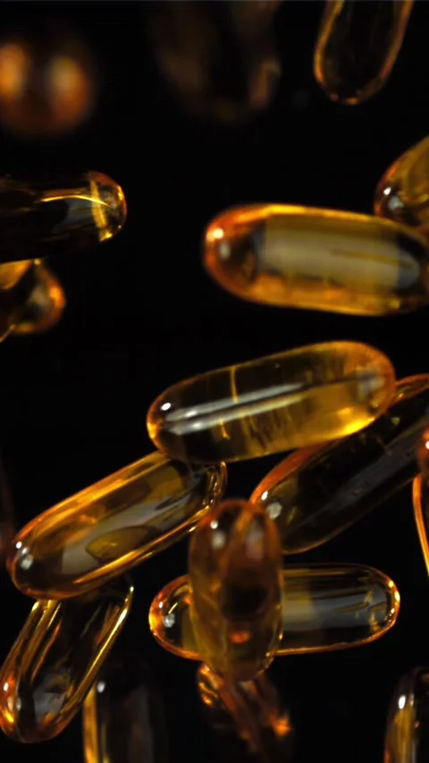 Amber softgels floating on black evoke premium health appeal Filmed on a high Stock Footage 335396538