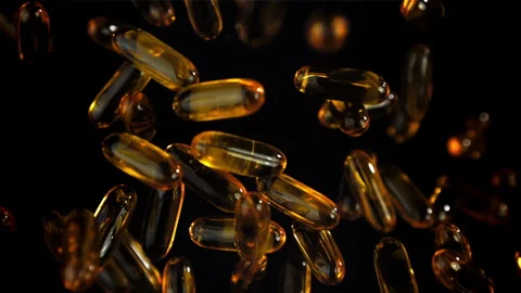 Amber softgels floating on black evoke premium health appeal Filmed on a high Stock Footage 335424585