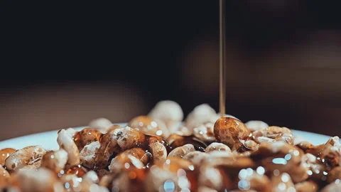 Amber Syrup Drizzling on Crispy Puffed Cereal Close-up Stock Footage 335895105
