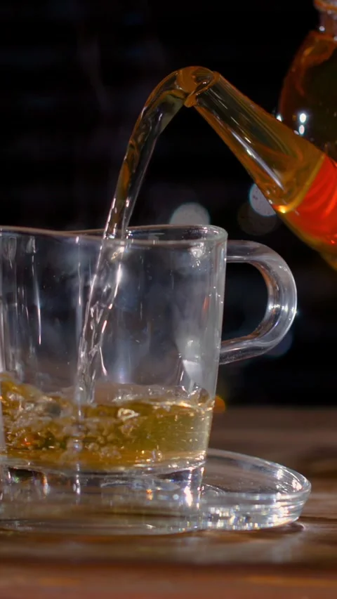Amber Tea Pours Into Transparent Cup, Cinematic Closeup Of Warm Tea Flowing Into Stock Footage 327095846