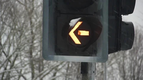 Amber traffic light arrow in rain or snow Stock Footage 86620618