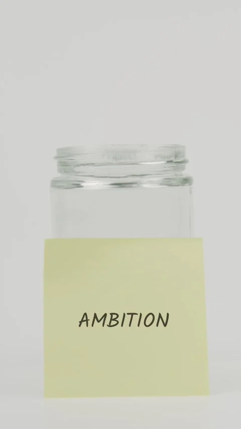 Ambition text or word on yellow sticky note attached to glass jar with hand Stock Footage 311677174
