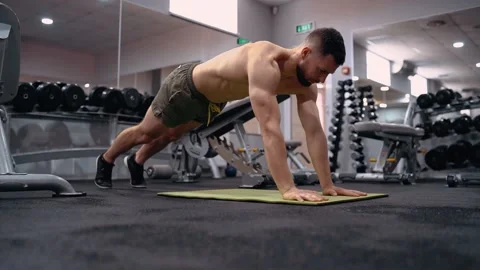 The ambitious bodybuilder does plank on his elbows and palms. Intense masculine Stock-Footage 156869790