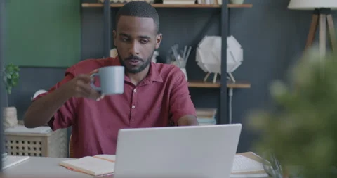 Ambitious freelancer using laptop typing and drinking tea from mug working at Stock Footage 246588075