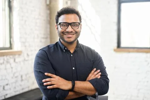 Ambitious hindu man in smart casual shirt stands with arms crossed Stock Photos