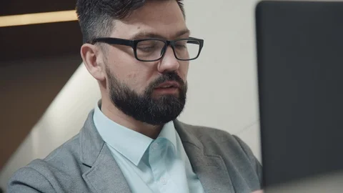 Ambitious man with glases and beard: he sits in front of the laptop Stock Footage 91286135