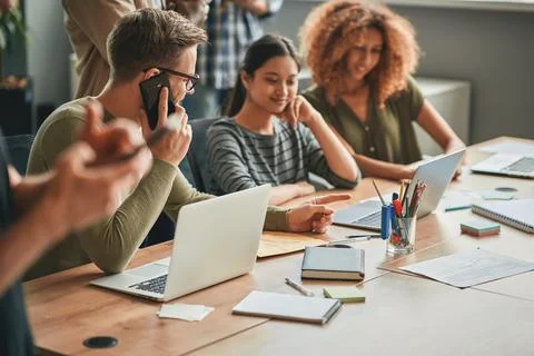 Ambitious man working side by side with young women Stock Photos