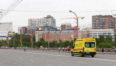 An ambulance accompanies the runners Stock Photos