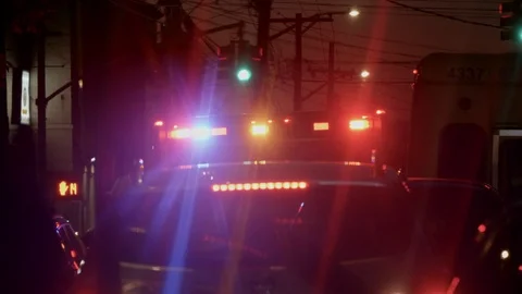 An ambulance with bright lights glaring at the scene of an altercation Stock Footage 115987202