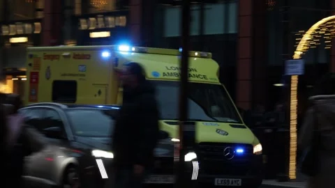 Ambulance car driving fast through busy car traffic on London streets. Stock Footage 334134578