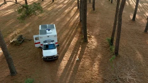 An ambulance converted into a camper is parked in the forest. Stock Footage 339911969