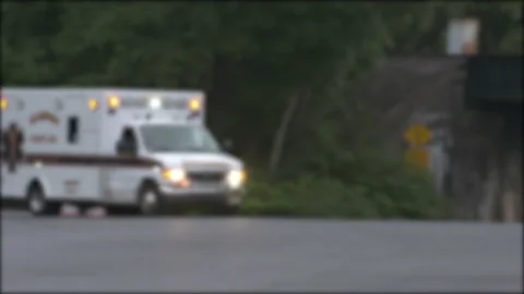 Ambulance Drives Across Intersection Evening Blurry 4K Stock Footage 146247014