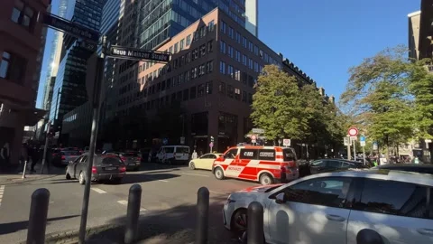 An ambulance drives through an intersection in heavy traffic in downtown Stock Footage 218303493
