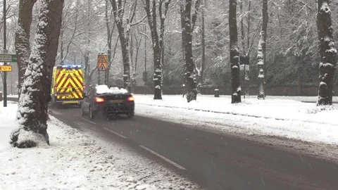 Ambulance Driving Down Main Road with Blue Lights in Icey Conditions 库存影片 83275454
