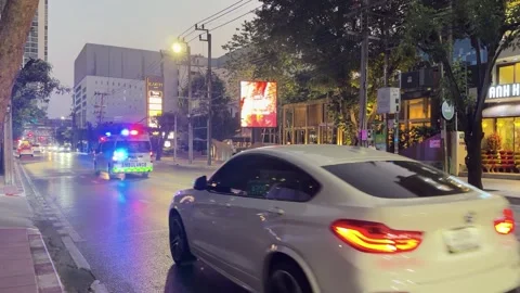 Ambulance with Flashing Lights Driving Through Night City Street in Bangkok Stock Footage 333604834