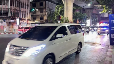 Ambulance with Flashing Lights Navigating Busy Night Traffic in Bangkok Stock Footage 329014510