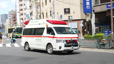 Ambulance with flashing lights riding down the street. Tokyo, Japan. Stock Footage 246797229
