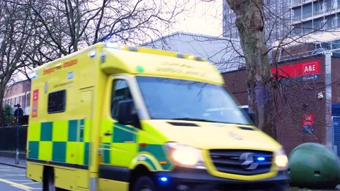Ambulance leaving UK hospital on emergency call Stock Footage