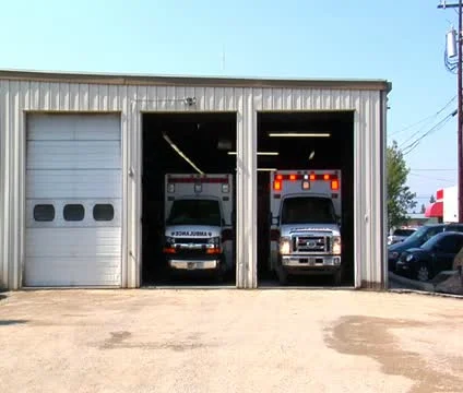 Ambulance with lights pulls out, drives away Stock Footage 21626556