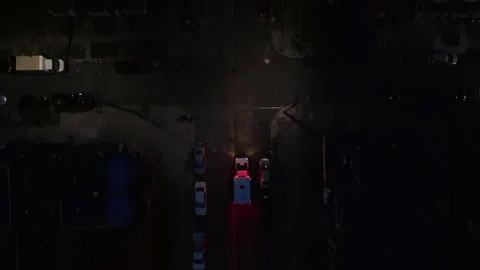 Ambulance navigating dark city streets at night with emergency lights on. Video stock 277387025