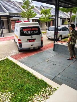 An ambulance is parked in reverse in a housing complex. Stock Photos