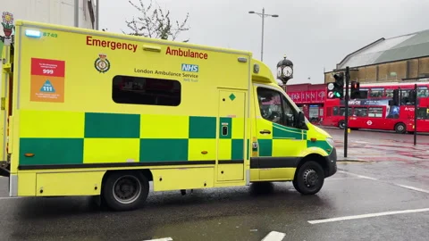 An ambulance pulls away slowly from a murder crime scene and passes a Stock Footage 159578458