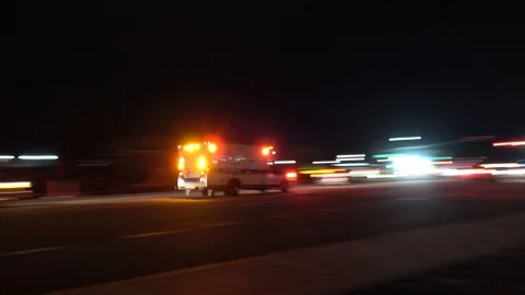 Ambulance races down the street in reponse to emergency Stock Footage