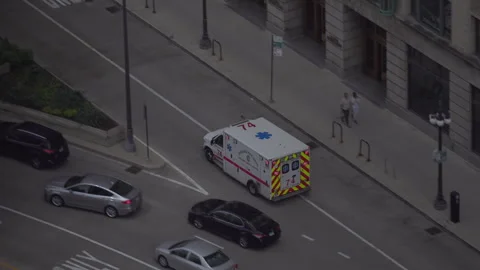 An ambulance with sirens blaring passes on Wacker Drive Stock Footage 240546540