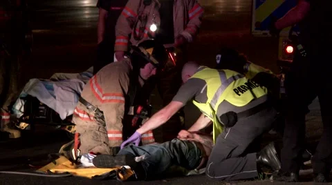 Ambulance staff turning pedestrian accident victim on its back Stock Footage