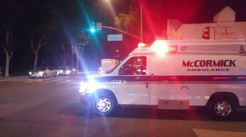 Ambulance van with flashing red lights rushing through night city street. 4K UHD Stock Footage