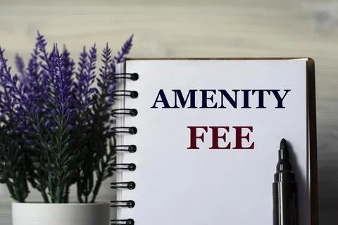 AMENITY FEE - word in a notepad with a marker and a bouquet of lavender on a Stock Photos