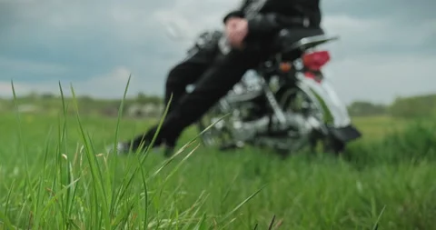 ?amera rises from the lower angle to a motorcyclist sitting on the seat of a  Stock Footage 135916267