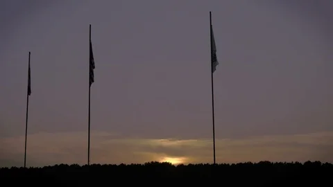 American and Arkansas Flags Silhouetted by sunset in 4k Stock Footage