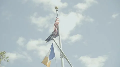 American and POW Flags tilt up sky clouds Stock Footage 250351437