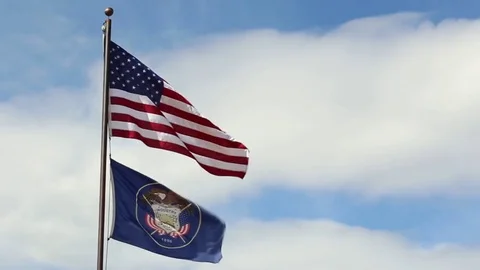 American and utah state flags blowing in the wind Stock Footage 82304616